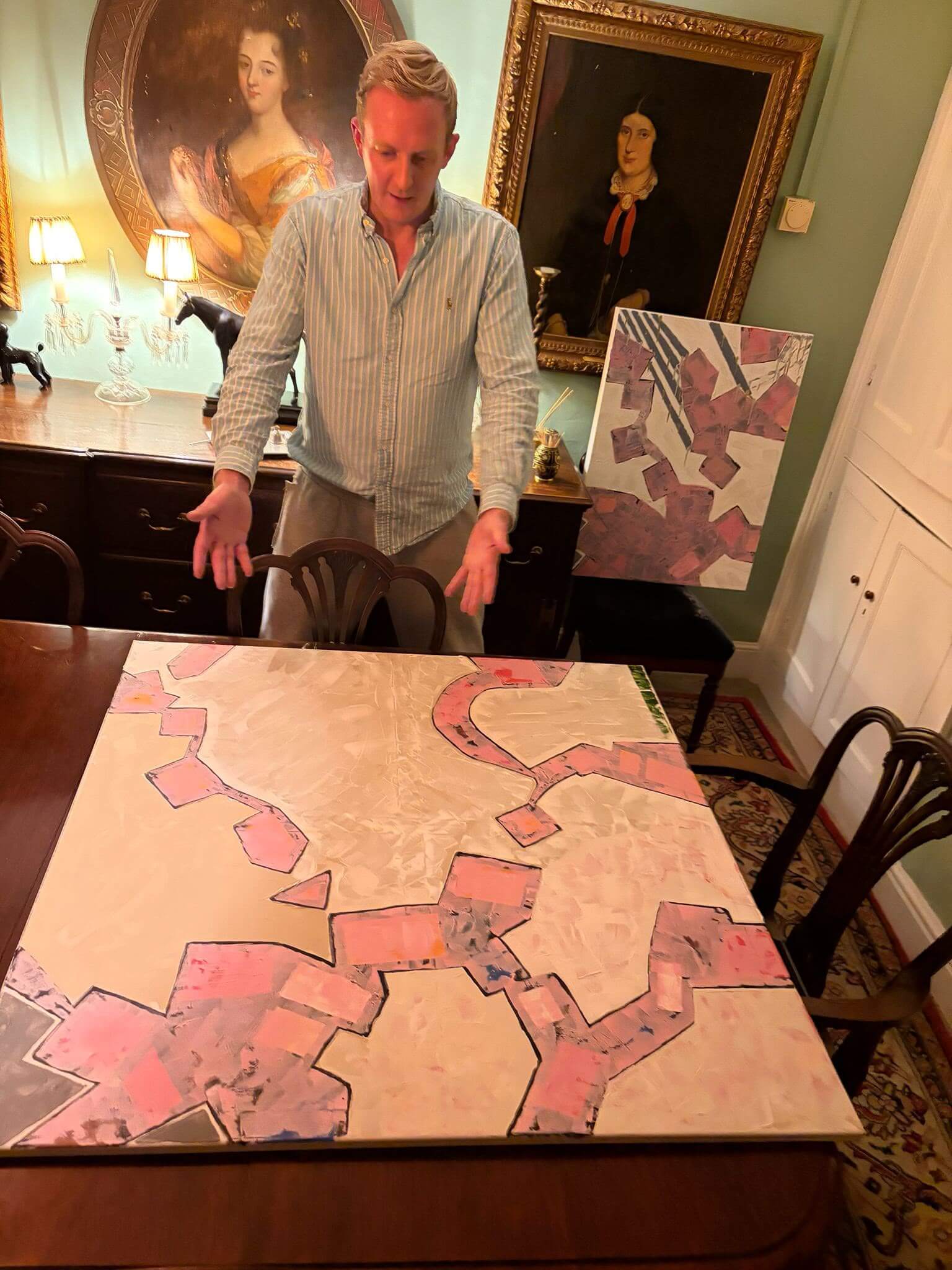 “Nicholas Le Ny‑Clarke, artiste peintre contemporain, présentant une peinture abstraite géométrique dans un intérieur classique.”